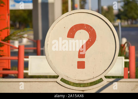 Punto interrogativo rosso scritto su una circolare della scheda in metallo Foto Stock