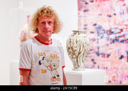 Londra, Regno Unito. 24 settembre 2019. Artista Grayson Perry pone accanto a uno dei vari ceramica smaltata a photocall per lanciare la sua prima mostra personale, 'Super ricca decorazione interna', presso il Victoria Miro Mayfair gallery. Nuovo lavoro comprese pentole, scultura, stampe di grandi dimensioni, un arazzo e un tappeto sono sul display 25 Settembre al 20 dicembre 2019. Credito: Stephen Chung / Alamy Live News Foto Stock