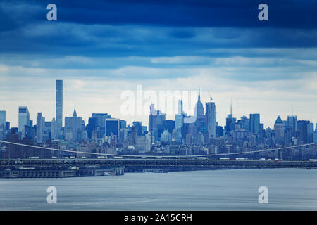 Vista di New York downtown dal nord del fiume Hudson oltre il Ponte George Washington Bridge su moody nuvoloso meteo Foto Stock