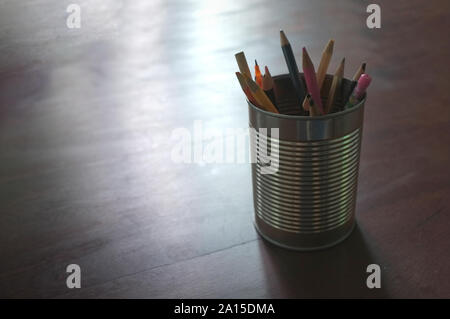 Penne e matite a barattolo di latta, tavolo in legno , concetto si torna a scuola Foto Stock