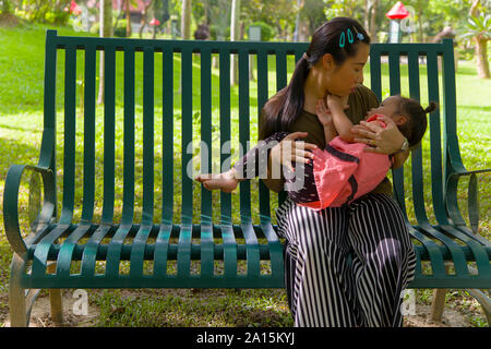 Giovane madre abbraccia e calmante di un pianto piccola figlia, Asian madre cercando di comfort e di calmare il suo pianto bambino immagine ad alta risoluzione galler Foto Stock