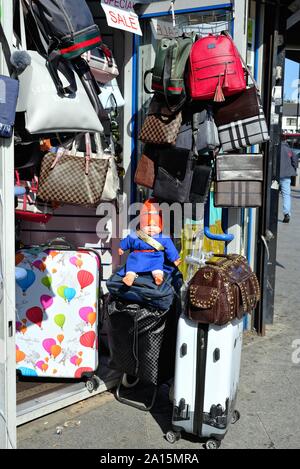 Una bambola realistica vestito in abiti tradizionali al di fuori di un negozio di vendita al dettaglio la vendita di borse e valigie su South Road Southall West London Inghilterra England Regno Unito Foto Stock