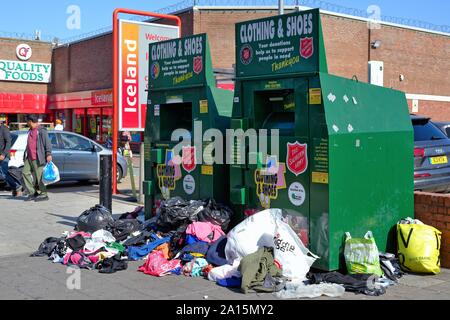 Traboccante Esercito della Salvezza vecchio abbigliamento e calzatura cassonetti sul marciapiede in South Road Southall West London Inghilterra England Regno Unito Foto Stock