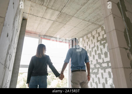 Coppia felice di futuri proprietari al sito in costruzione Foto Stock