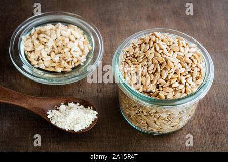 Grani antichi, Einkorn Weat nel vasetto di vetro sotto forma di grani, scaglie e farina Foto Stock