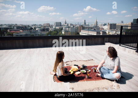 Donna con sotto-gomito amputazione e la ragazza avente un pasto sano sul tetto Foto Stock