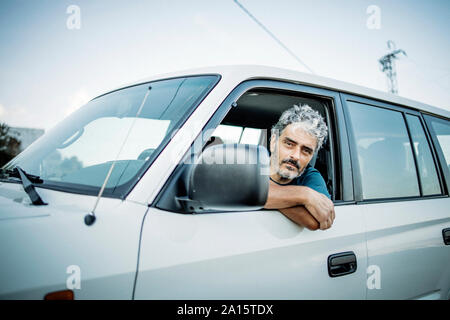 Uomo maturo seduto nel suo veicolo fuoristrada Foto Stock