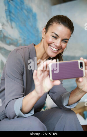 Felice imprenditrice utilizza lo smartphone Foto Stock