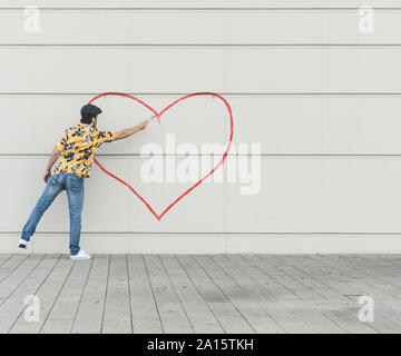 Composito Digitale del giovane aheart disegno a una parete Foto Stock