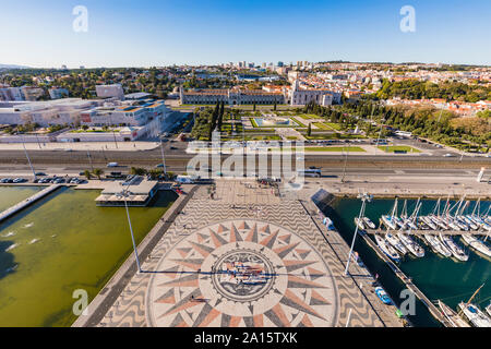 Il Portogallo, Lisbona, Belem, ad alto angolo di visione della rosa dei venti e il mosaico della mappa vicino marina, il Monastero di Jeronimos in background Foto Stock