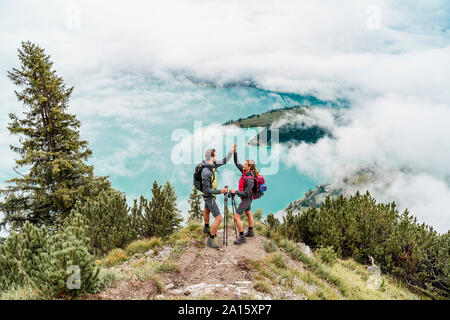 Felice coppia giovane su un escursione in montagna alta fiving, Herzogstand, Baviera, Germania Foto Stock