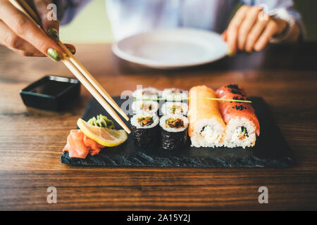 Close-up di una donna di mangiare sushi in un ristorante Foto Stock