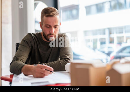 Architetto operante sul piano in ufficio Foto Stock