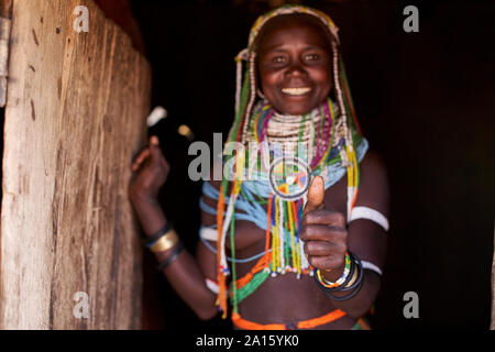 Ritratto di un tradizionale Muhila donna in piedi nella sua casa, dando humbs fino, Congolo, Angola Foto Stock