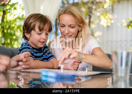 Madre e Figlio la riproduzione di un gioco da tavolo sulla terrazza Foto Stock