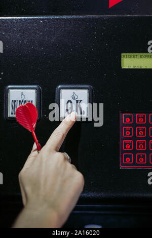 Close-up di donna di commutazione a mano su electronic dartboard Foto Stock