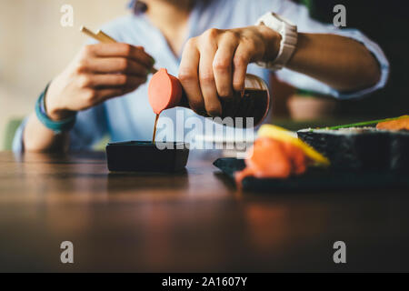 Close-up di una donna di mangiare sushi in un ristorante Foto Stock