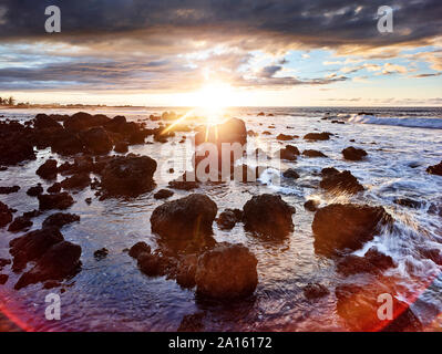 Le rocce vulcaniche nella baia di Makalawena contro sky durante il tramonto Foto Stock