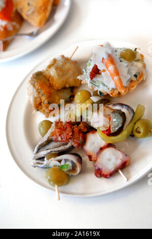 Close up di tapas spagnole su una piastra bianca in un ristorante Foto Stock