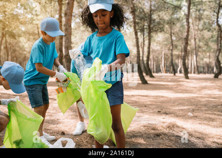 Gruppo di volontariato bambini raccogliere rifiuti in un parco Foto Stock