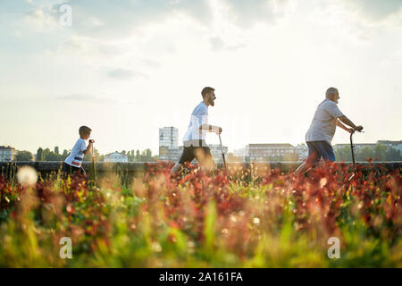Nonno, padre e figlio in sella scooter su un lungomare Foto Stock
