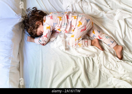 Vista superiore della cute bambina dormire nel letto Foto Stock