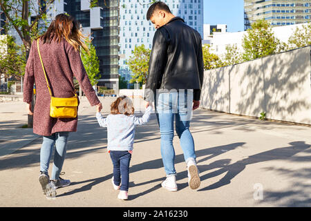 I genitori e la bambina per mano e camminare insieme a Barcellona, Spagna Foto Stock