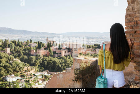 Vista posteriore del giovane donna guardando l'Alhambra di Granada, Spagna Foto Stock