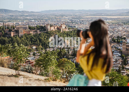 Giovane donna di scattare una foto a La Alhambra di Granada, Spagna Foto Stock