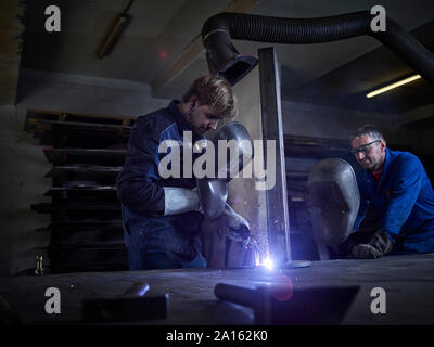 Saldatura del lavoratore in fabbrica Foto Stock