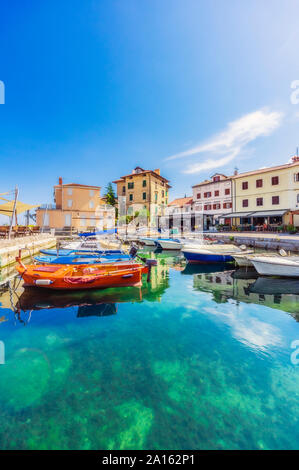 Barche ormeggiate in mare da quartiere residenziale a Opatija contro sky Foto Stock