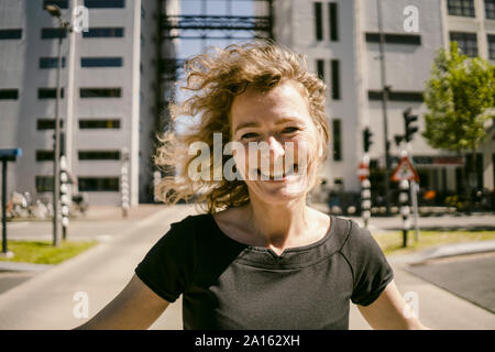 Ritratto di ridere imprenditrice maturo con i capelli di soffiatura Foto Stock