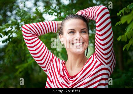 Ritratto di donna felice con capelli bagnati indossando striped top in natura Foto Stock