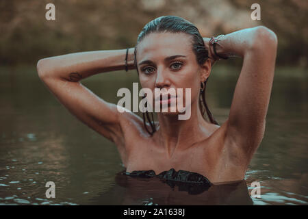 Ritratto di giovane donna bionda di balneazione in un lago Foto Stock