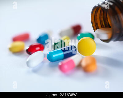 Una varietà di farmaci in caduta da un flacone di farmaco. Foto Stock