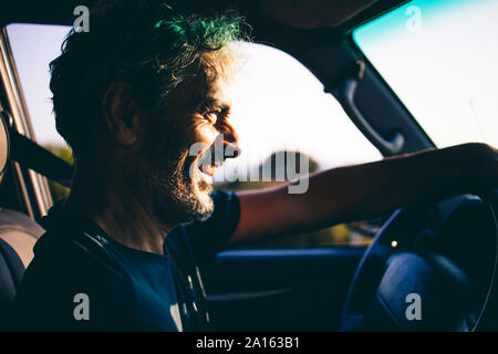 Uomo maturo la guida al tramonto Foto Stock