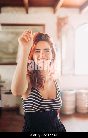 Ritratto di felice giovane donna giocare a freccette in un bar sport Foto Stock