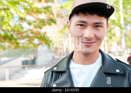 Ritratto di fiducioso giovane uomo indossando giacca di pelle e cappello, Barcellona, Spagna Foto Stock