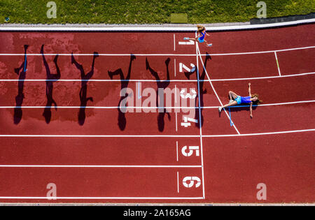 Vista aerea di un acceso e giacente giovane atleta femminile su una pista di tartan Foto Stock