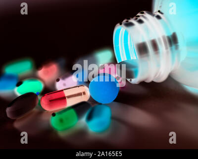 Una varietà di farmaci in caduta da un flacone di farmaco. Foto Stock