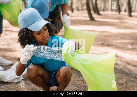 Gruppo di volontariato bambini raccogliere rifiuti in un parco Foto Stock