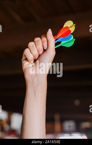 Close-up di donna di mano azienda freccette Foto Stock