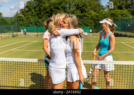 Donne mature la finitura match di tennis su erba corte avvolgente Foto Stock