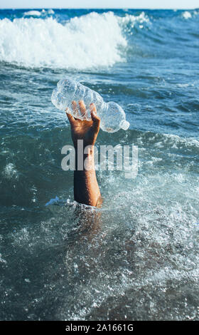 Mano d'uomo di prelevare la bottiglia di plastica Foto Stock