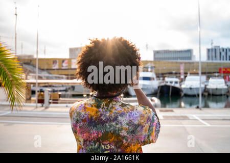 Vista posteriore dell'uomo con una telecamera indossare magliette colorate Foto Stock