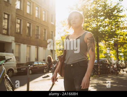 La donna tatuata sulla strada in città Foto Stock