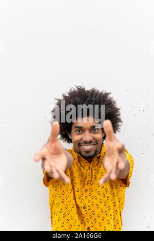 Giovani sorridente hipster indossando maglietta gialla, mani Foto Stock
