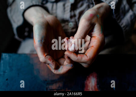 Close-up di mani dipinte di una femmina di pittore nel suo studio Foto Stock