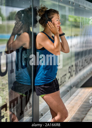 Giovane donna sportive indossando le cuffie Foto Stock