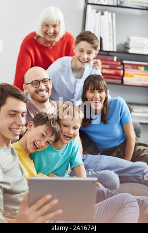 Famiglia di grande divertimento a casa, utilizzando tavoletta digitale Foto Stock